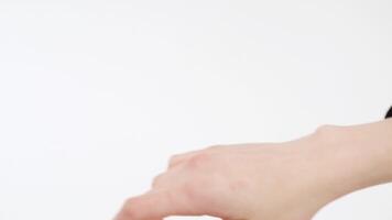 Close up for woman hand putting on black hoodie, isolated on white background. Close up process of putting on black turtleneck, stretching woman hand into a sleeve. video