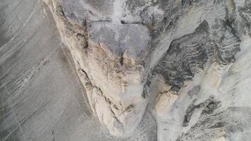 aéreo parte superior ver para asombroso blanco acantilado cerca verde Valle en hermoso, nublado cielo antecedentes. disparo. blanco, alto rock acantilado cerca el campo con verde césped. video