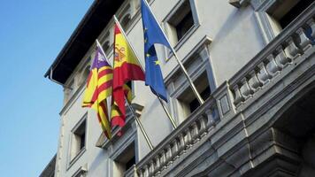 Flags of European countries on embassy house facade. Stock. Colorful banners fluttering in the wind on grey building background. video