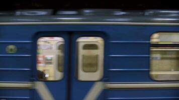 Blue subway train with people inside picking up speed, view from metro station. Close up for windows of subway train passing fast at underground station. video