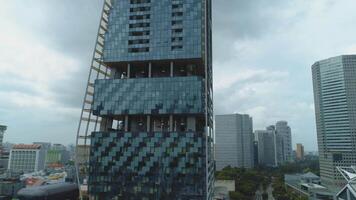 antenne detailopname verbijsterend visie van de elegant kantoor gebouw in downtown wijk. schot. mooi wolkenkrabber in bewolkt weer video