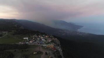 bahía de el mar, montañas, rocas, terraplén y ciudad edificios a el puesta de sol aéreo vista. disparo. aéreo de puesta de sol. aéreo Disparo de increíble montañas y rocas en un costa video