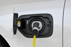 Power cable pump plug in charging power to electric vehicle EV car. photo