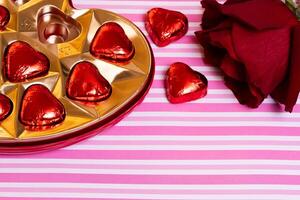 box of chocolates and rose valentines day pink and white background photo