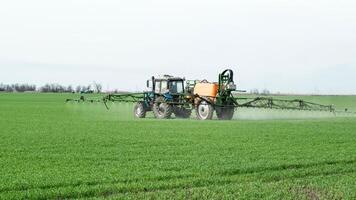 tractor con un rociar dispositivo para finamente disperso fertilizante. foto