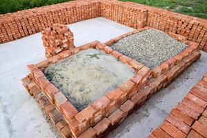 The red brick folded neatly on the foundation of the house. Home construction photo