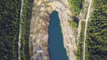 Beautiful view from a road going through the beautiful lake and forest top view. Clip. Trees and road near the lake. Green water. Mountains video