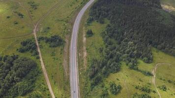 Country muddy road aerial view. Clip. Aerial view of cars driving on road in forest video