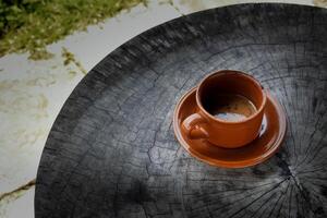 cup of hot chocolate coffee in cup on black wooden table taken from top view photo