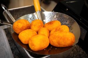 Jemblem, a traditional sweet croquette from Java, is made from cassava with butter and flour. Cooked in hot oil and fried, then dried on a bamboo tray. It is round and tastes sweet. close-up view. photo