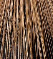 The texture of the palm fiber broom, which is often used to sweep floors or clean dirty wall surfaces, can be seen from the front with natural lighting. photo