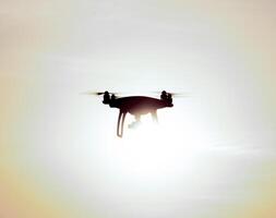 cuadricópteros silueta en contra el antecedentes de el puesta de sol foto