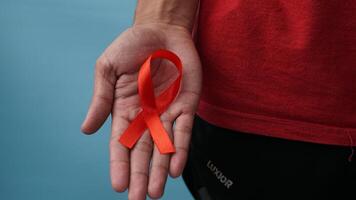 man holding red ribbon in his hand supports world awareness day photo