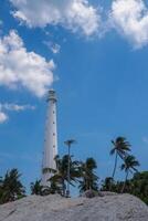 faro en contra azul nublado cielo en un pequeño isla en belitung, Indonesia foto