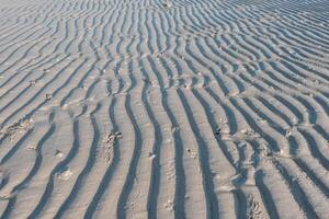 Low angle view of line pattern on sand created by waves in Belitung Island beach, Indonesia. Belitung is one of the most popular tourist destinations in Indonesia. photo