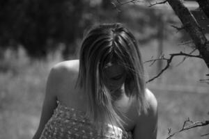 Black and white photo, girl in the garden on a meadow in a dress. photo