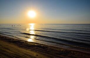 mar puesta de sol. personas bañarse en el noche a puesta de sol en el mar. foto