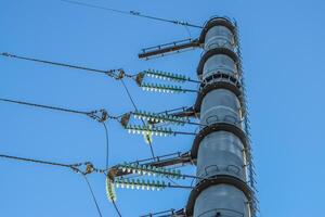 Supports high-voltage power lines against the blue sky photo