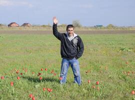 un hombre en un chaqueta en un campo de tulipanes claro con tulipanes foto