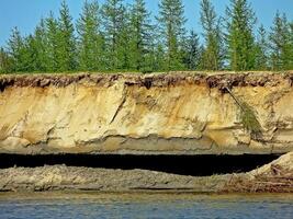 Crumbled cliff on the river bank. photo