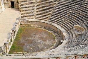 Ancient antique amphitheater in city of Hierapolis in Turkey. Steps and antique statues with columns in the amphitheater photo