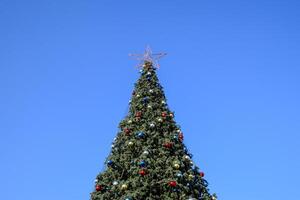 decoraciones nuevo año árbol. oropel y juguetes, pelotas y otro decoraciones en el Navidad Navidad árbol en pie en el abierto aire. foto