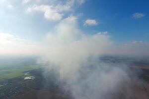 The smoke over the village. Clubs of smoke over the village houses and fields. Aerophotographing areas photo