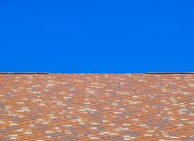 Roof from multi-colored bituminous shingles. Patterned bitumen shingles. photo