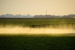 chorros de líquido fertilizante desde el tractor pulverizador. foto