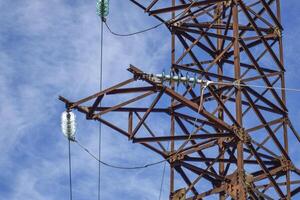 Supports high-voltage power lines against the blue sky with clou photo