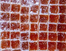 Cubes of marmalade, powdered with powdered sugar. Background from cubes of marmalade photo