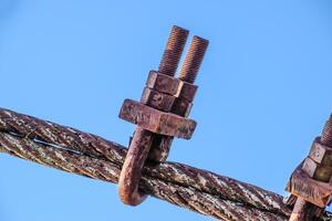 Fastening clamp on the steel cable of the bridge photo