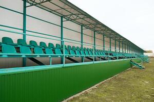 filas de asientos en un vacío estadio. verde asientos a el estadio foto