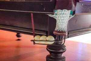 A bowl with balls of a billiard table. Billiard table in the roo photo