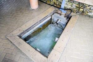 un pequeño nadando piscina con santo agua desde el primavera. un nicho en el piso para reclutamiento agua desde un fuente foto