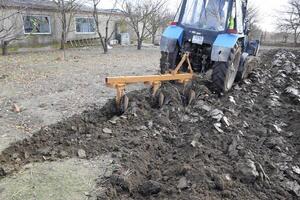 Tractor plowing the garden. Plowing the soil in the garden photo