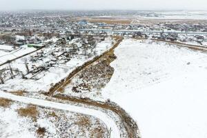 Sprinkled with snow grain elevator. Winter view of the old Soviet elevator. Winter view from the bird's eye view of the village. The streets are covered with snow photo