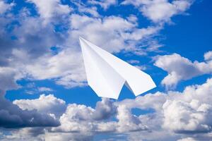 blanco papel avión en un azul cielo con nubes el mensaje símbolo en el Mensajero foto