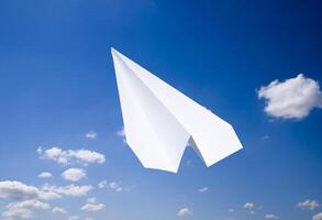 White paper airplane in a blue sky with clouds. The message symbol in the messenger photo