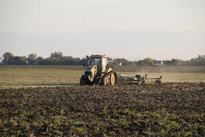 tractor arada arado el campo. labranza el suelo en el otoño después cosecha. el final de el temporada foto