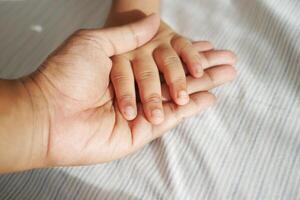 father holding hand of baby child, photo