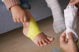 Elastic therapeutic yellow tape applied to child leg. photo