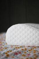 Orthopedic memory foam pillow on bed photo