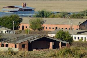 antiguo abandonado edificios de el ex fábrica y almacenes. el destruido esencial petróleo planta. Soviético herencia. antiguo ladrillo edificios asentamiento en el kuban. foto