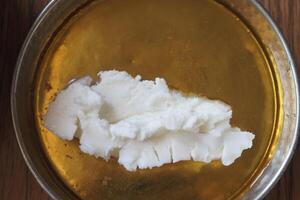 butter cream and honey in a bowl on table . photo