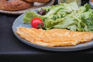 huevo tortilla servido con ensalada en mesa foto