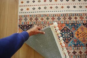 top view of men hand rolling out new rug. photo