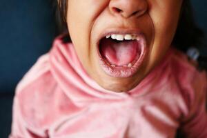 close up of child screaming at home photo