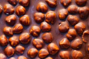 Milk chocolate with crashed hazelnuts background photo