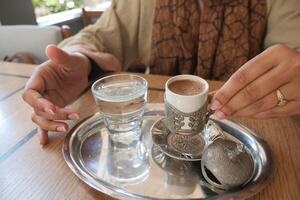 women drinking turkish coffee at cafe photo